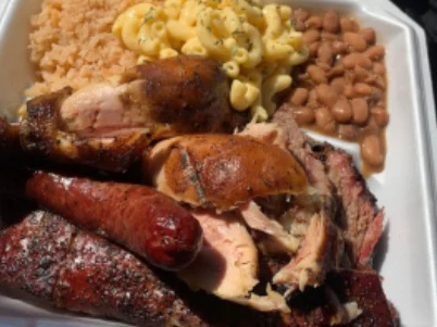 The Big Boy Plate - A loaded plate featuring a little bit of everything — brisket, sausage, ribs, and all the classic sides. For the serious BBQ lover.